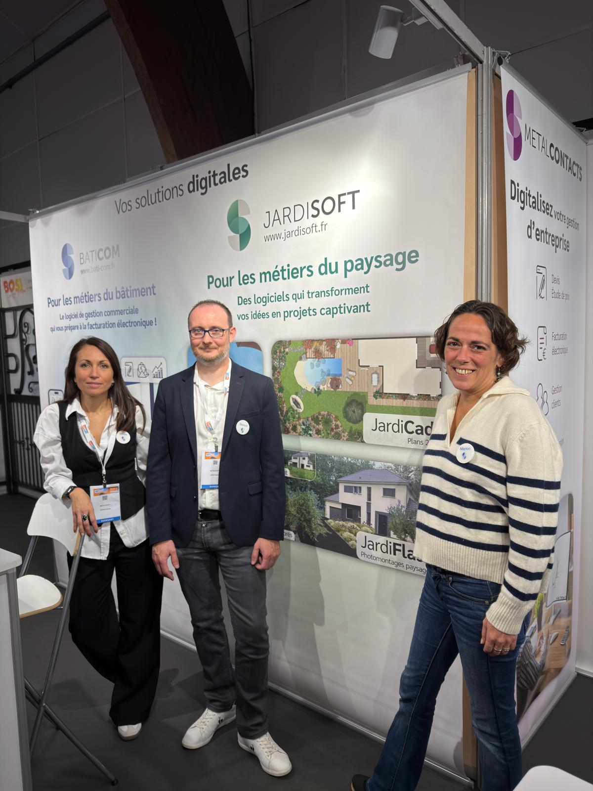 Trois personnes devant un stand d'exposition Jardisoft.